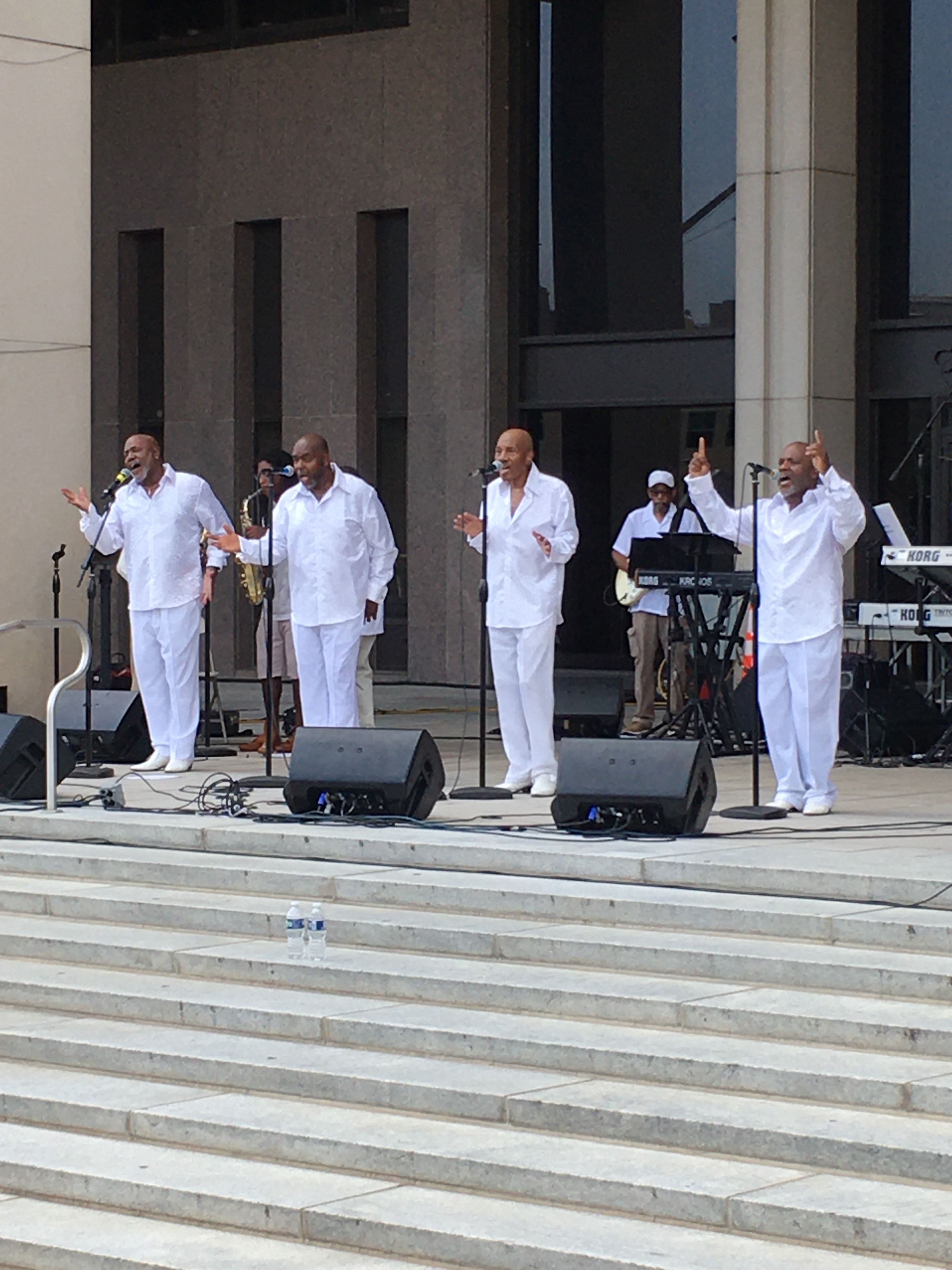 Performers in white on outdoor stage