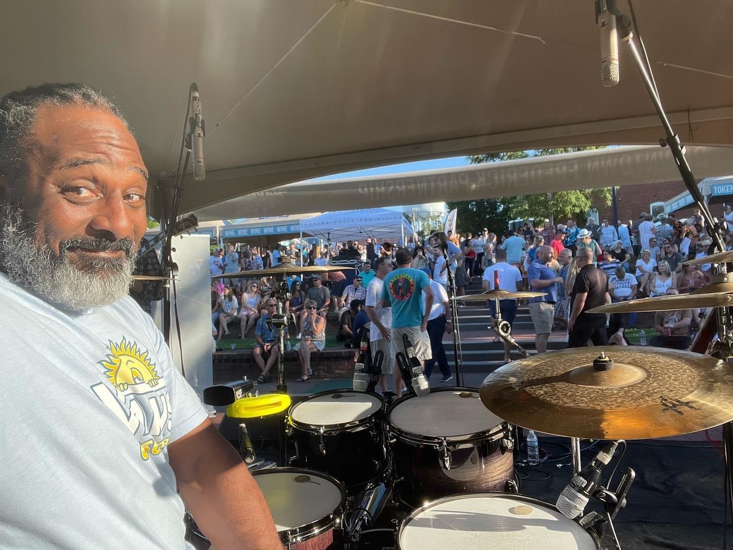 Drummer performing at outdoor festival with crowd